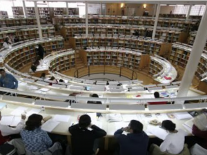 stock image of the backs of students overlooking books at the library of Carlos III University of Madrid